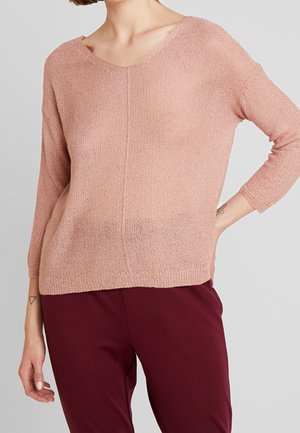 Pull en maille rose clair avec un col en V, des manches trois-quarts et une coupe ample, comportant un motif texturé et des poignets ourlés.
