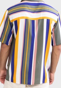 Chemise à manches courtes avec des rayures verticales dans des couleurs vert, jaune, bleu, rose et blanc ; tissu lisse avec une coupe décontractée.