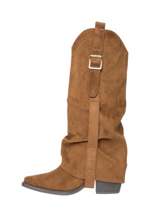 Botte de cowboy en daim marron avec bout pointu, design affaissé, sangle réglable avec boucle argentée, et talon bas empilé.