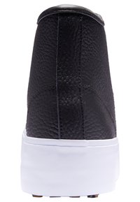 Černé kožené tenisky s texturovaným povrchem, bílou podrážkou a zaoblenou zadní částí. Vyznačují se elegantním designem a minimálními detaily.
