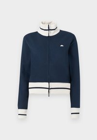 Marineblå zip-up hettegenser med høy krage, kremfargede ribbestrikkede mansjetter og liv. Har en liten logo på brystet og stripete detaljer.