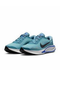 Světle modré sportovní boty s texturovaným povrchem, černým logem Swoosh a bílou mezipodešví. Mají modré akcenty a aerodynamický design.