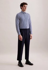 Gestreept overhemd met knopen in blauw en wit, gecombineerd met donkere broek en zwarte schoenen. Slim fit ontwerp met klassieke kraag en lange mouwen.