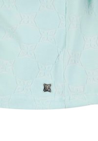 Tela de color azul claro con un patrón en relieve de mariposas interconectadas, con un acento metálico en forma de estrella plateada adjunto.