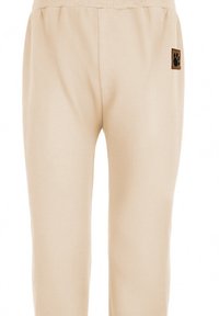 Beżowe bawełniane spodnie dresowe z prążkowanym pasem i małą brązową naszywką w kształcie śladu łapy po lewej stronie. Miękka tekstura, prosty krój nogawek.