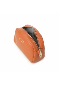 Oranje leren cosmetica-etui met een ronde vorm, gouden rits hardware en een geperst logo. Gevoerde binnenkant met een zachte textuur.