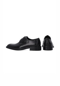 Schwarze Lederschuhe mit glatter Oberfläche, runder Zehenpartie, Schnürdesign und einer niedrigen, flachen Gummisohle. Rückansicht zeigt einen leichten Absatz.
