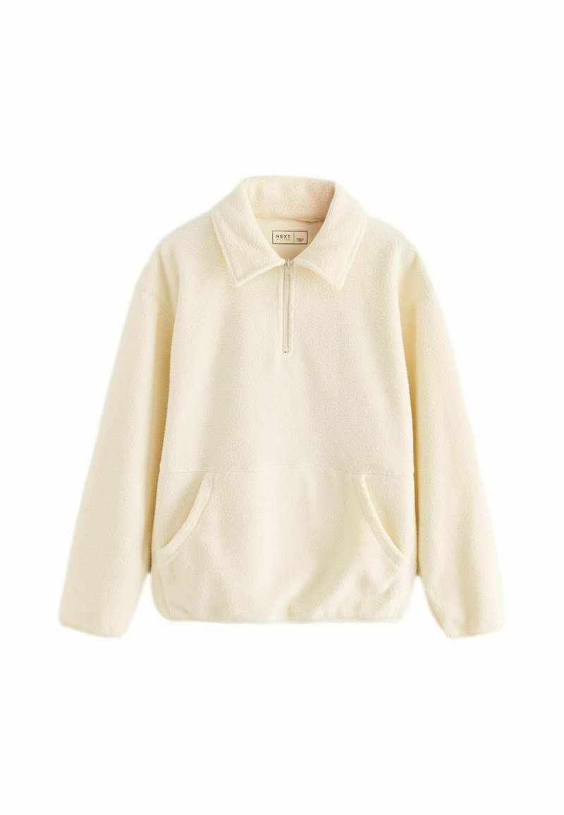Kermainen fleece-pullove, jossa on vetoketjullinen kaulus, kaksi etutaskua ja rento istuvuus. Pehmeä tekstuuri ja minimalistinen muotoilu tarjoavat lämpöä.