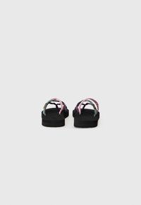 Sandalene med en tykk svart såle og flerfargede stropper—rosa, grønn og lilla—med en teksturert finish og minimalistisk design.