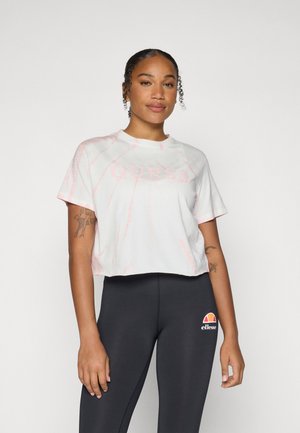 Cropped white t-shirt with pink tie-dye pattern and "GUESS" logo. Worn with black leggings featuring a colorful ellesse logo. Smooth fabric.