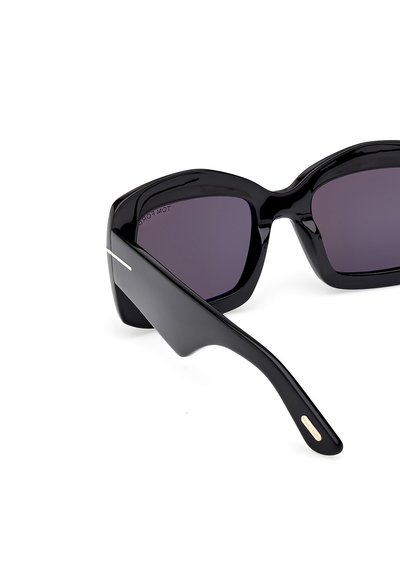 Schwarze Sonnenbrille mit glänzender Oberfläche, übergroßer quadratischer Form, dunkel getönten Gläsern und subtilen metallischen Akzenten an den Seiten.