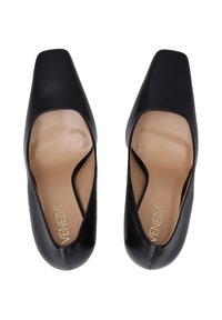 Black leather shoes with a square toe and cut-out design. Interior features a beige insole. Textured exterior with smooth finish.