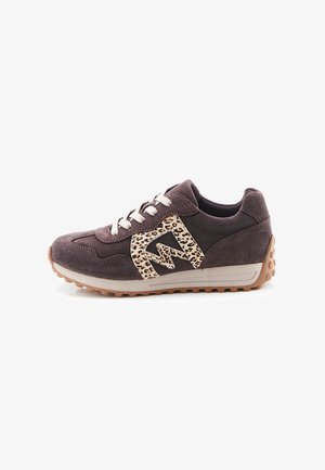 Zapatilla de ante marrón oscuro con cordones blancos, suela gruesa beige y detalle estampado de leopardo en forma de zigzag en el lateral.