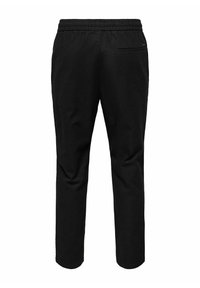 Pantalones jogger negros de material suave, con cinturilla elástica, piernas ajustadas y un bolsillo trasero con cremallera.