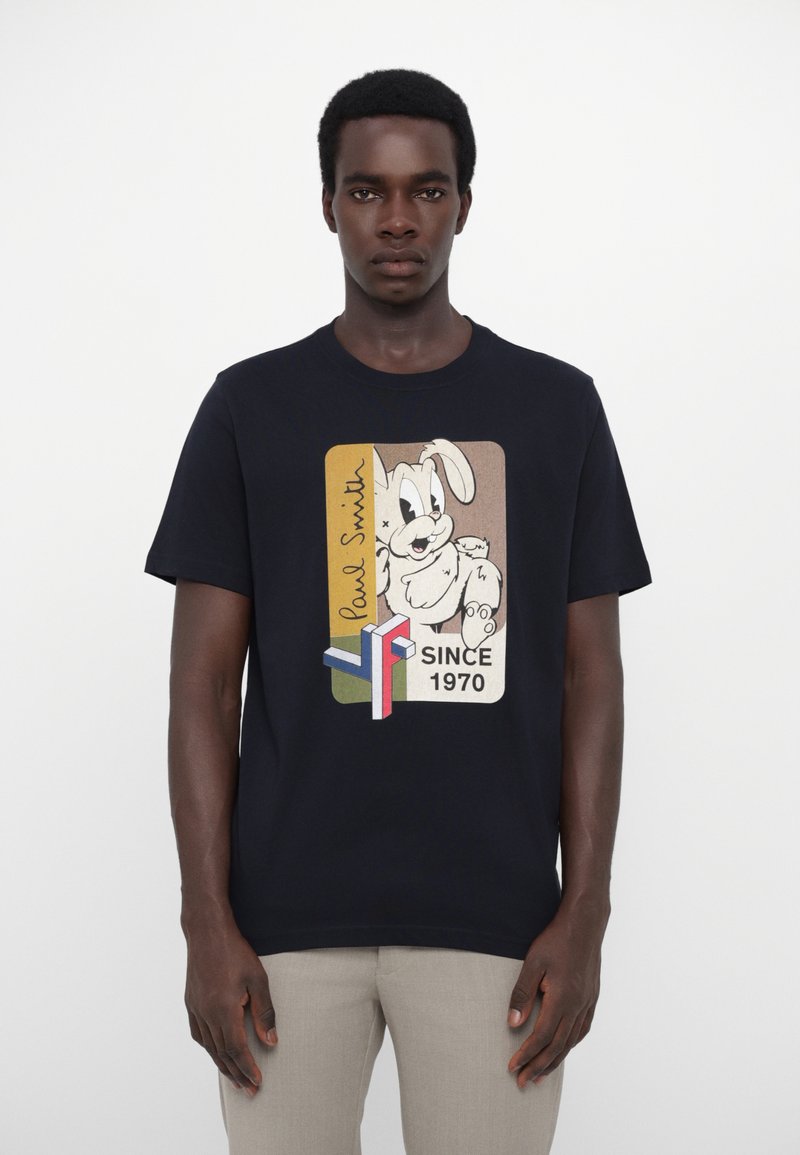 T-shirt en coton bleu marine avec un graphisme de lapin de dessin animé, "Paul Smith," et le texte "SINCE 1970" dans des accents rectangulaires colorés.