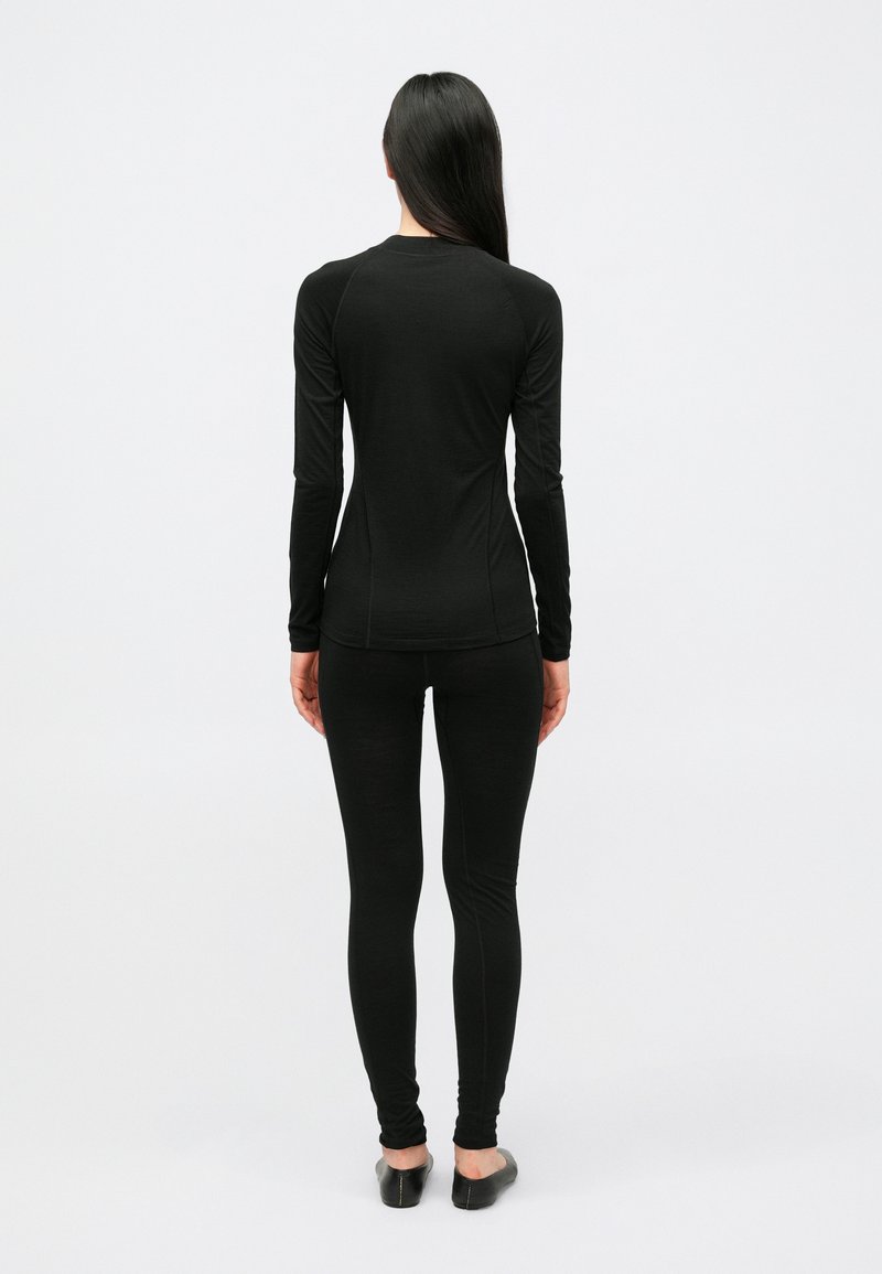 Black long-sleeve top and leggings made from a smooth fabric, fitted design, featuring subtle seams, with a minimalist silhouette.
