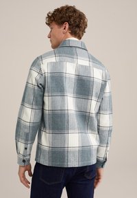 Camicia di flanella a quadri blu e bianca con colletto, polsini con bottone e trama a spina di pesce, caratterizzata da un orlo diritto e un dettaglio con yoke sul retro.