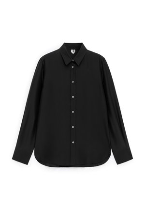 Chemise noire à manches longues avec col pointu, poignets boutonnés et ourlet arrondi, présentée sur un fond blanc.