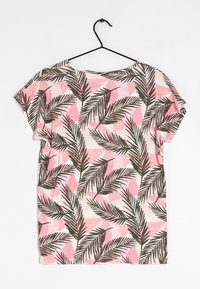 Camiseta de manga corta con un corte relajado, que presenta un patrón de hojas tropicales en tonos rosa, blanco y verde oscuro sobre un fondo claro.