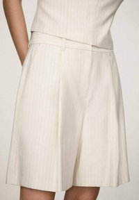 White, pinstriped shorts with a tailored fit, featuring a flat front, belt loops, and folded hem. Made of lightweight fabric.