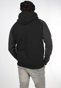 Hoodie met een grijze voorkant en zwarte mouwen, beschikt over een relaxte pasvorm en een zachte textuur, met ribgebreide cuffs en onderrand.