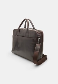 Brown leather laptop bag with dual handles, adjustable shoulder strap, smooth texture, and a zip closure. Features a rear pocket for added storage.