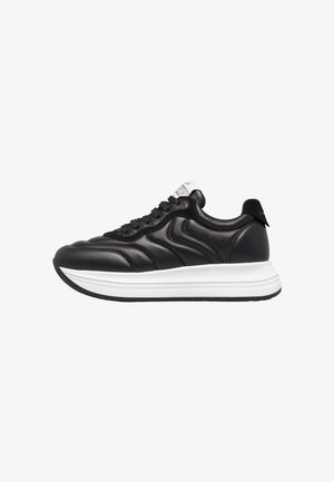 Baskets en cuir noir avec semelle blanche, présentant une texture sur le corps, un devant lacé et un design bas. Agrémentées d'une étiquette logo grise.