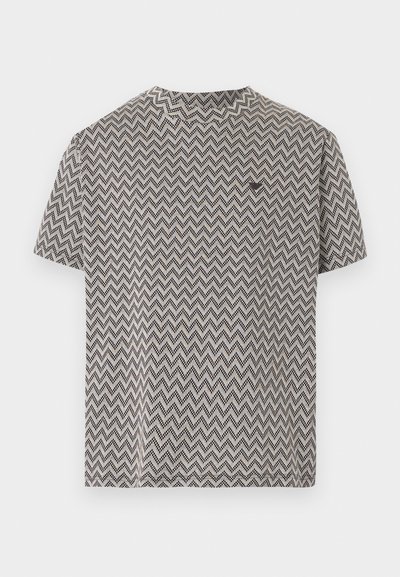 Κοντομάνικο μπλουζάκι με ασπρόμαυρο ζιγκ-ζαγκ μοτίβο και στρογγυλή λαιμόκοψη, τοποθετημένο επίπεδα σε λευκό φόντο.