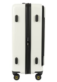 Valigia rigida con finitura bianca opaca, zip nera e maniglie. Presenta quattro ruote con accenti gialli per la mobilità.