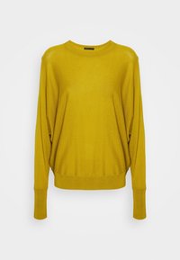 Maglione oversize in giallo senape con scollatura rotonda e lunghi maniche scese. Tessuto testurizzato con orlo e polsini a costine.