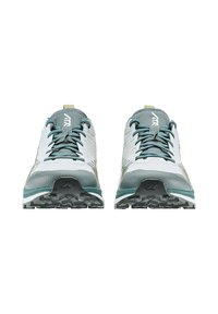 Scarpe sportive bianche e teal con una tomaia in rete testurizzata, lingua imbottita e suola in gomma con lugs di trazione multidirezionali.