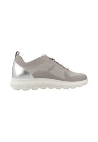 Zapatilla de deporte de punto gris con acentos plateados, suela redondeada y parte superior de malla texturizada. Cuenta con un diseño de cordones y una lengüeta en el talón.