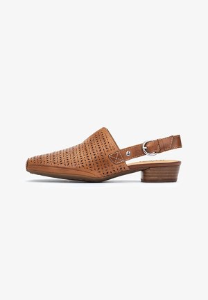 Zapato de piel marrón tipo slingback con un diseño perforado, punta afilada y un tacón bajo de madera. Presenta una hebilla decorativa en la correa.