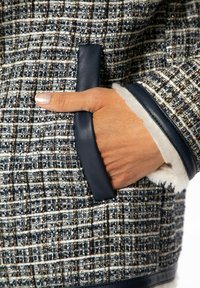 Strukturierte gewobene Jacke mit einem Marineblau- und Weißkaromuster und metallischen Akzenten. Verfügt über Lederbesätze und ein kuscheliges Fleecefutter.