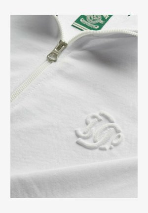 Witte zip-up sweatshirt van een gestructureerde stof, met een groene label en een subtiel geborduurd logo op de voorkant. De rits is zilver.