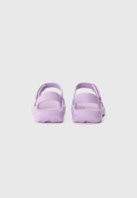 Violetit sandaalit tekstuuripannalla, avoimella takalla ja paksulla pohjalla. Valmistettu joustavasta materiaalista, minimalistinen muotoilu.