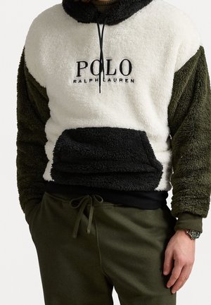 Blød fleece-hoodie i hvid, sort og olivengrøn med Polo Ralph Lauren-logo, kængurulomme og sorte snore, båret med olivengrønne bukser.