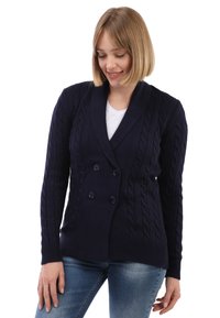 Cárdigan de punto de cable azul marino con cuello chal, botones de doble abotonadura y puños acanalados. Textura suave, ajuste entallado, diseño versátil.