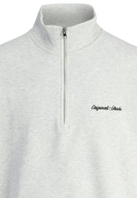 Grå sweatshirt med lynlås krave, lavet af blødt stof. Har en subtil tekstur og broderet "Originals Studio" logo på brystet.