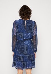 Blau gemustertes Kleid mit einer Mischung aus floralen und Paisley-Designs, durchsichtigen langen Ärmeln, einer taillierten Taille und einem gestuften Rock mit einem rückseitigen Schlüsselverschluss.