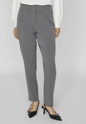 Pantalon gris ajusté avec une coupe droite, présentant une texture lisse et un motif de fines rayures, associé à des chaussures à talons noirs.