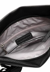 Black leather handbag interior with a gray lining, featuring a zippered pocket and a textured label. Smooth and functional design.