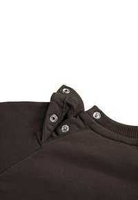 Suéter de algodón marrón con un cuello acanalado y tres broches a presión cerca del cuello, que presenta una textura suave y lisa con un acabado limpio.