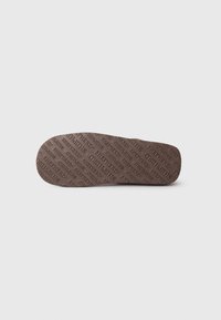 Brown shoe insole featuring a textured surface with the word "SHEPHERDS" repeated in a pattern. Smooth edges and a slightly rounded shape.