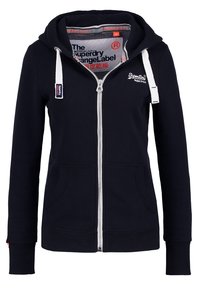 Marinblå zip-hoodie av mjukt material, med dragsko i huvan, framfickor och logodetaljer på bröstet och innerfodret.