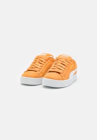 Orange suede sneakers with white rubber soles and laces. Features a contrasting white side stripe and a logo on the tongue.