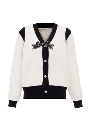 Czarny i biały kardigan w prążki, z głębokim dekoltem w serek, czarną kokardą z perłowym akcentem oraz sześcioma dekoracyjnymi zapięciami na guziki.