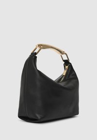 Schwarze Lederhandtasche mit geschwungenem Design, ausgestattet mit einem goldfarbenen Griff und einem Reißverschluss an der Seite. Glatte Textur.