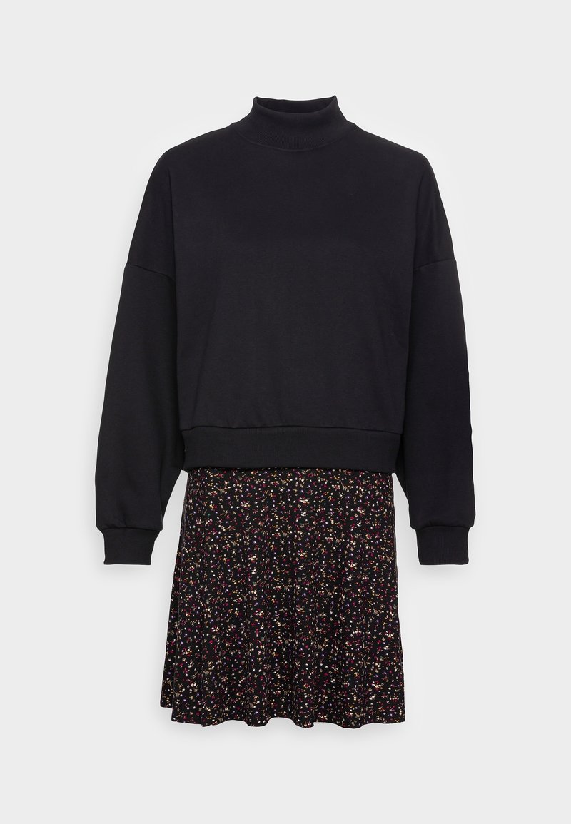 Sweat-shirt noir à col haut et manches longues, associé à une jupe patineuse noire à motifs floraux avec des accents multicolores.