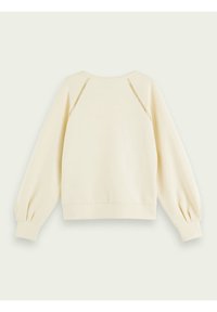 Felpa color crema con una vestibilità rilassata, maniche a sbuffo e dettagli decorativi in rete alle cuciture delle spalle. Tessuto morbido.